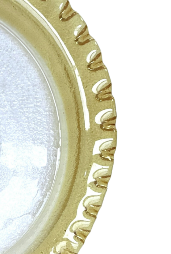 Decorative round object with gold rim and white center on a white background
