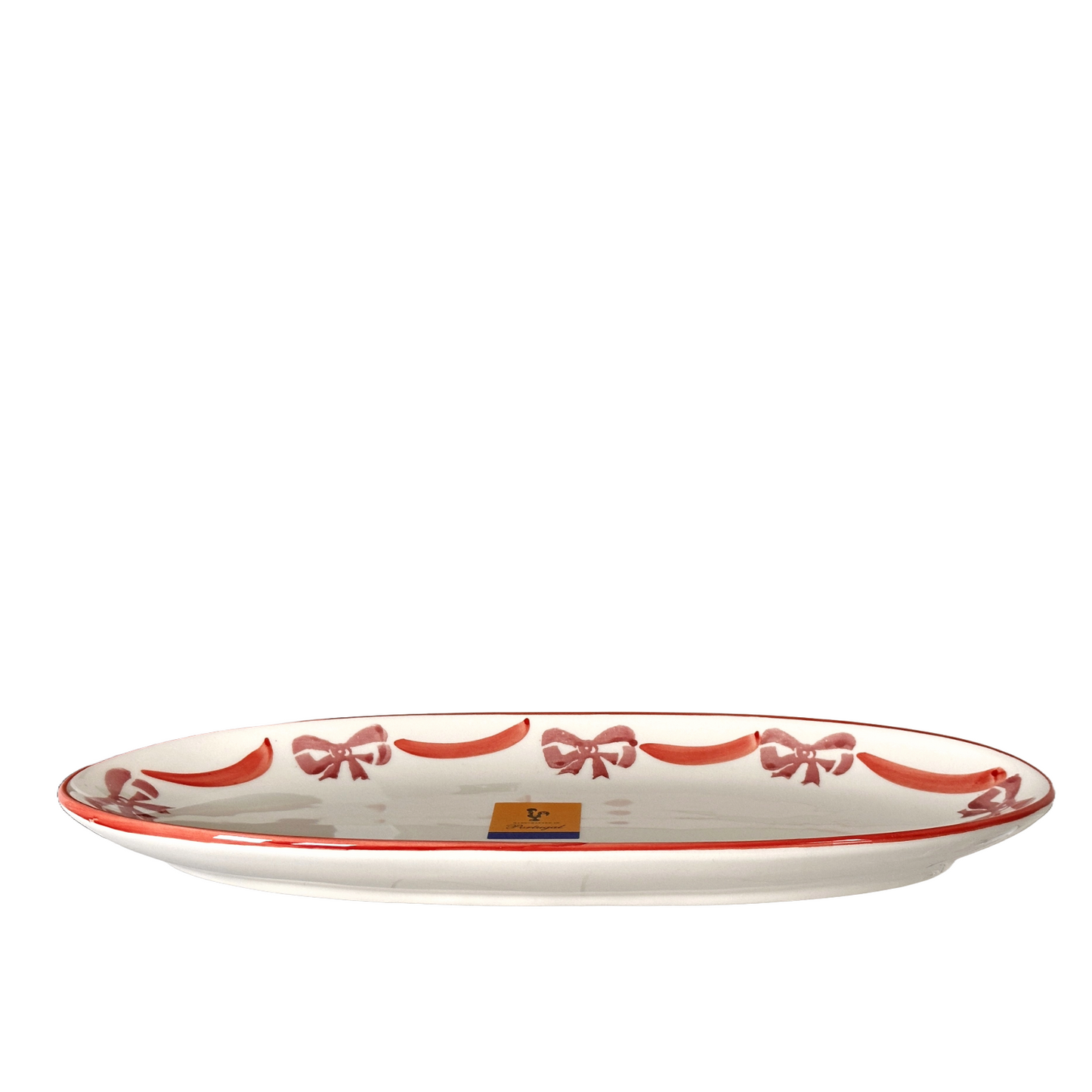 White oval plate with red decorative bows on a white background