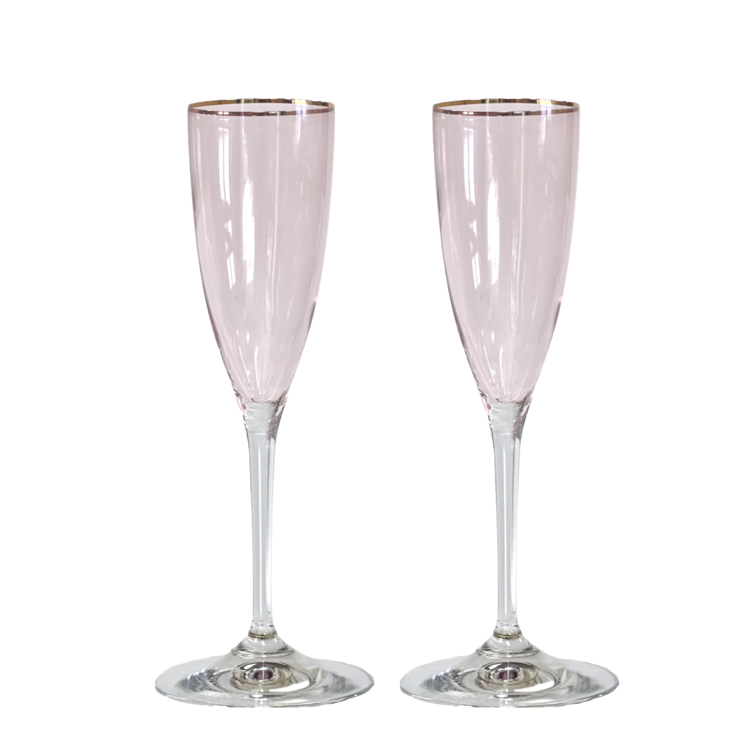 Two pink champagne flutes with gold rims on a white background