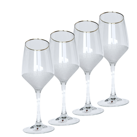 Set of four clear wine glasses with gold rims on a white background