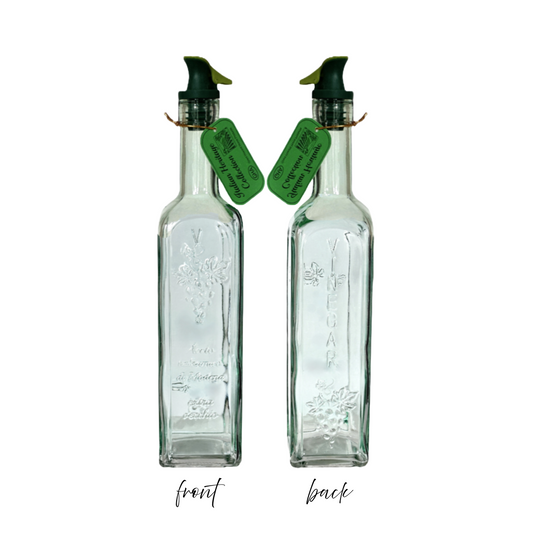 Two glass bottles with spray nozzles and green labels on a white background