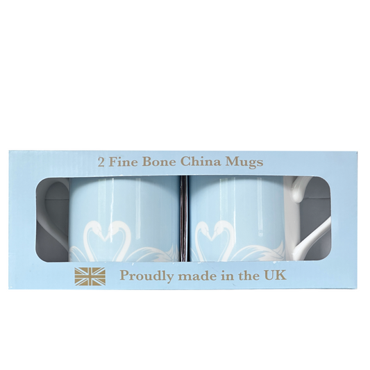 Two light blue mugs by Roy Kirkham with white swan designs on a white background