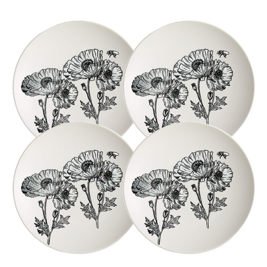 Four white ceramic plates with black floral designs 
