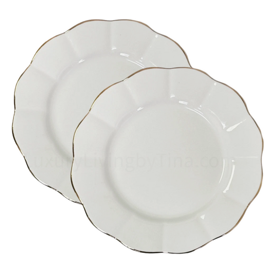 Two white ceramic plates with gold trim on a white background