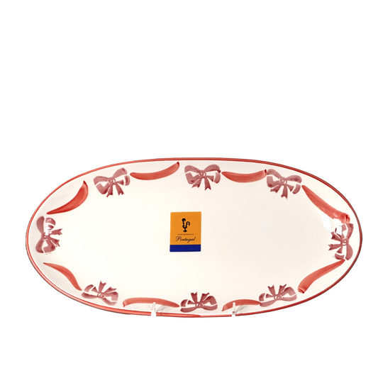Decorative oval plate with red bows and a brand logo on a white background