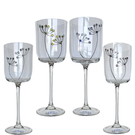 Set of four clear wine glasses with decorative designs on a white background
