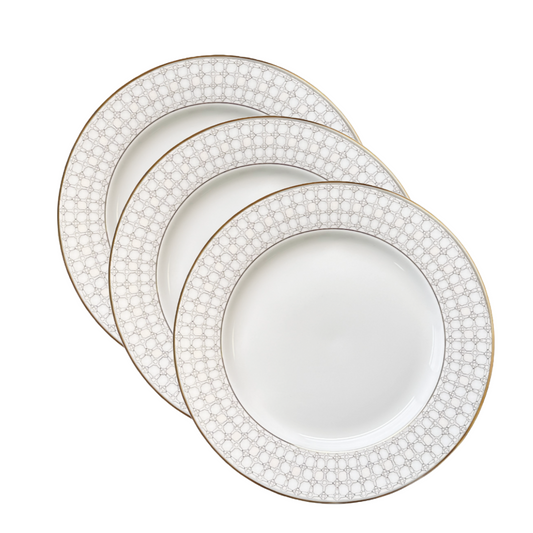 Set of three white plates with gold rim and decorative edge on a white background